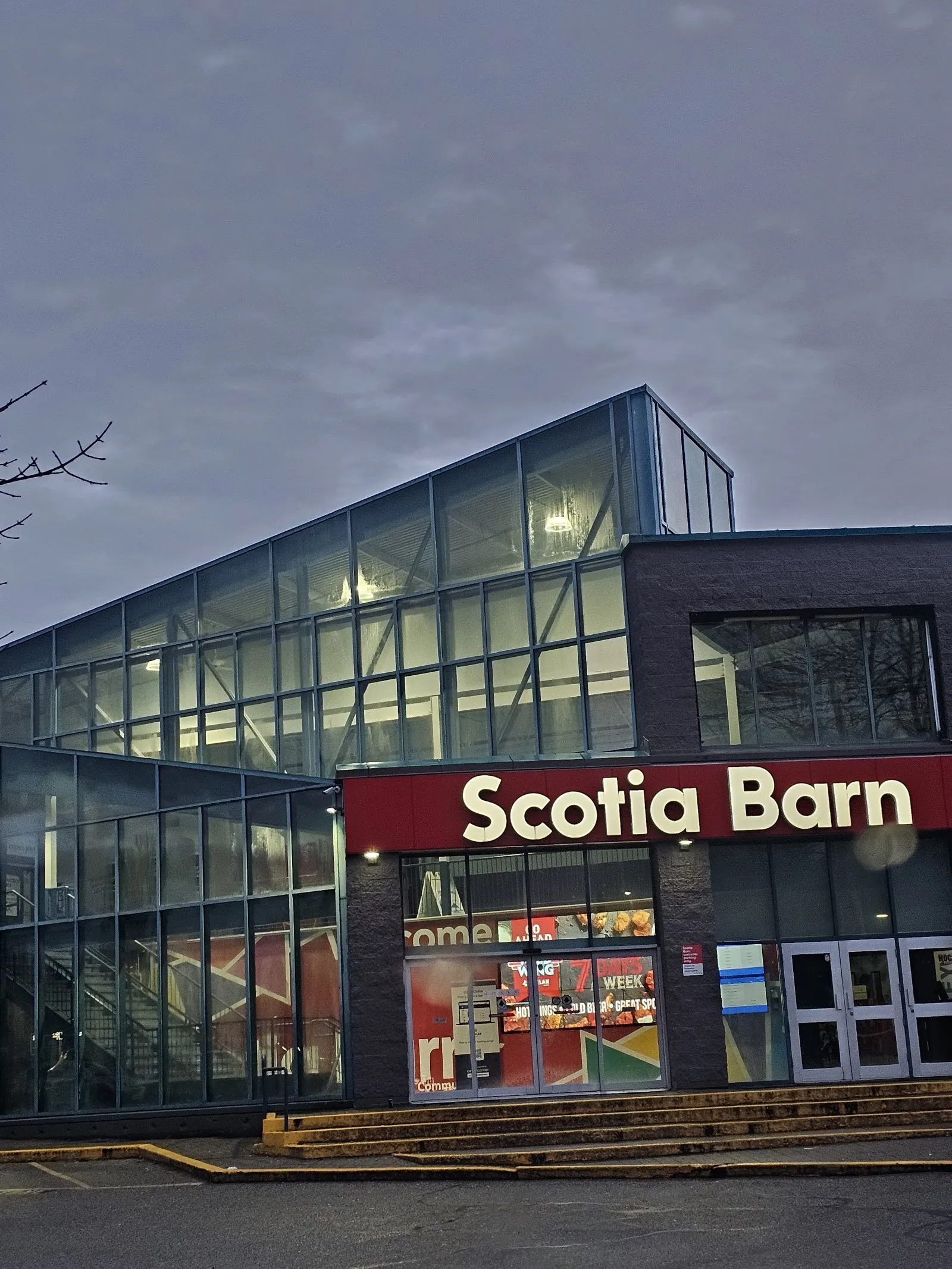 The glass and brick front of Scotia Barn in Burnaby at dusk, with the red Scotia Barn sign above the entrance — Scotia Barn