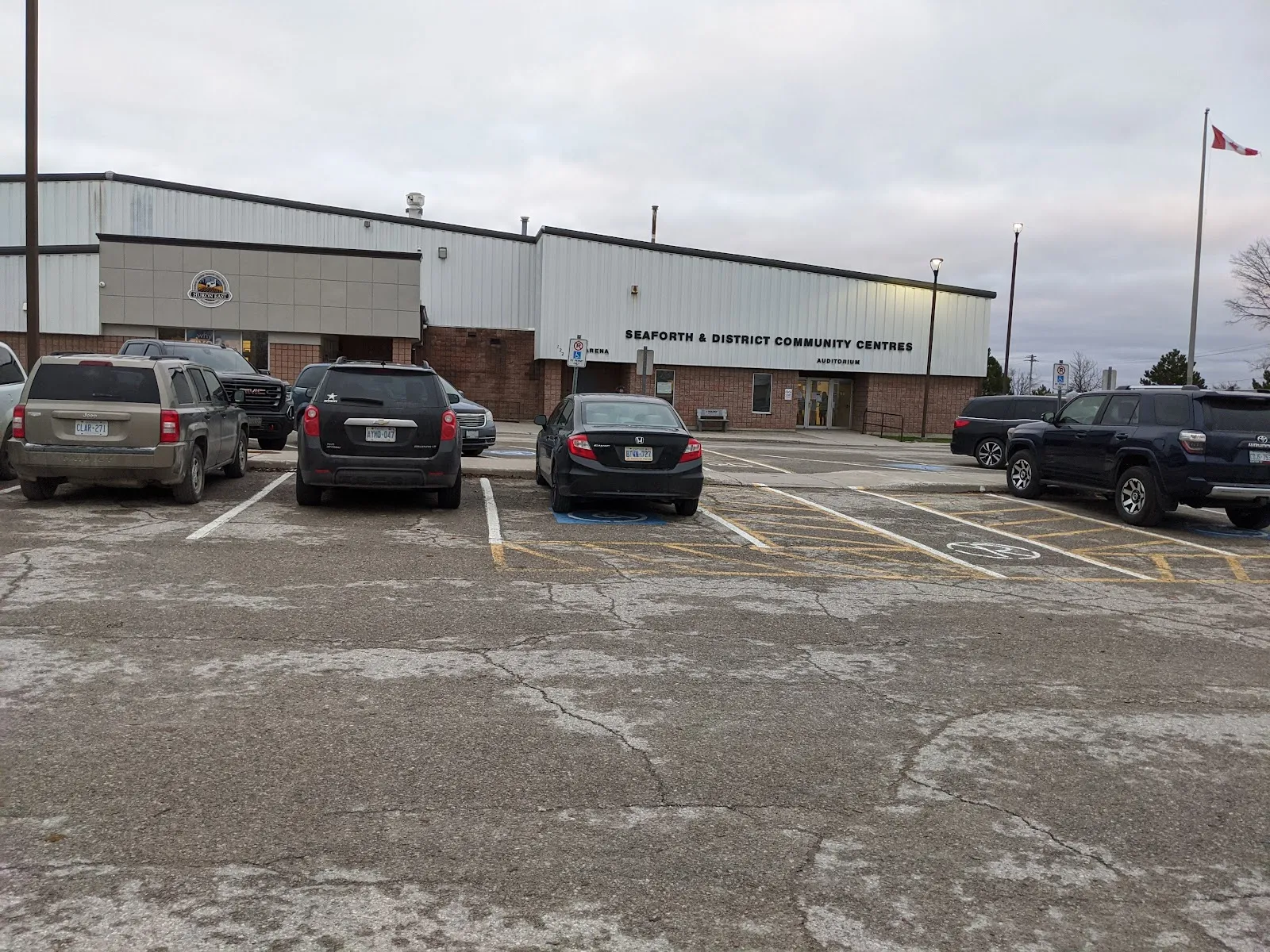 The long, low arena building with the Seaforth & District Community Centre sign over the entrance, seen across the parking lot. — Seaforth & District Community Centre