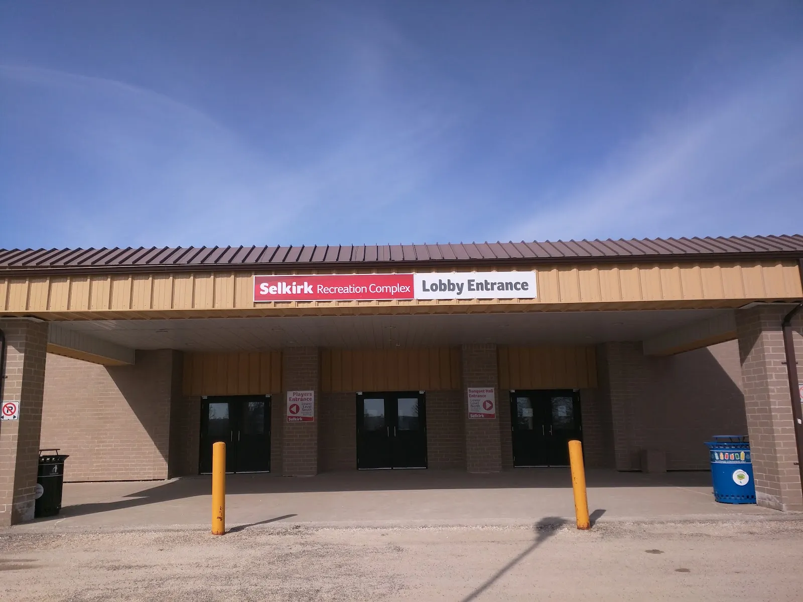 The covered lobby entrance of the Selkirk Recreation Complex with its name sign above the doors. — Selkirk Recreation Complex