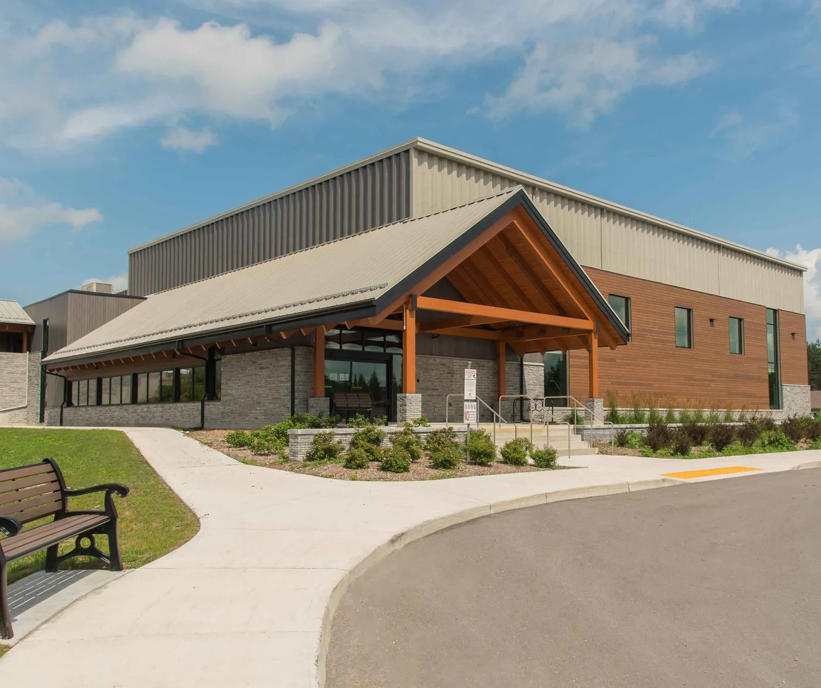 The Minden Hills Community Centre entrance, a timber-framed gable over glass doors, in front of the arena block. — S.G. Nesbitt Memorial Arena (Minden)