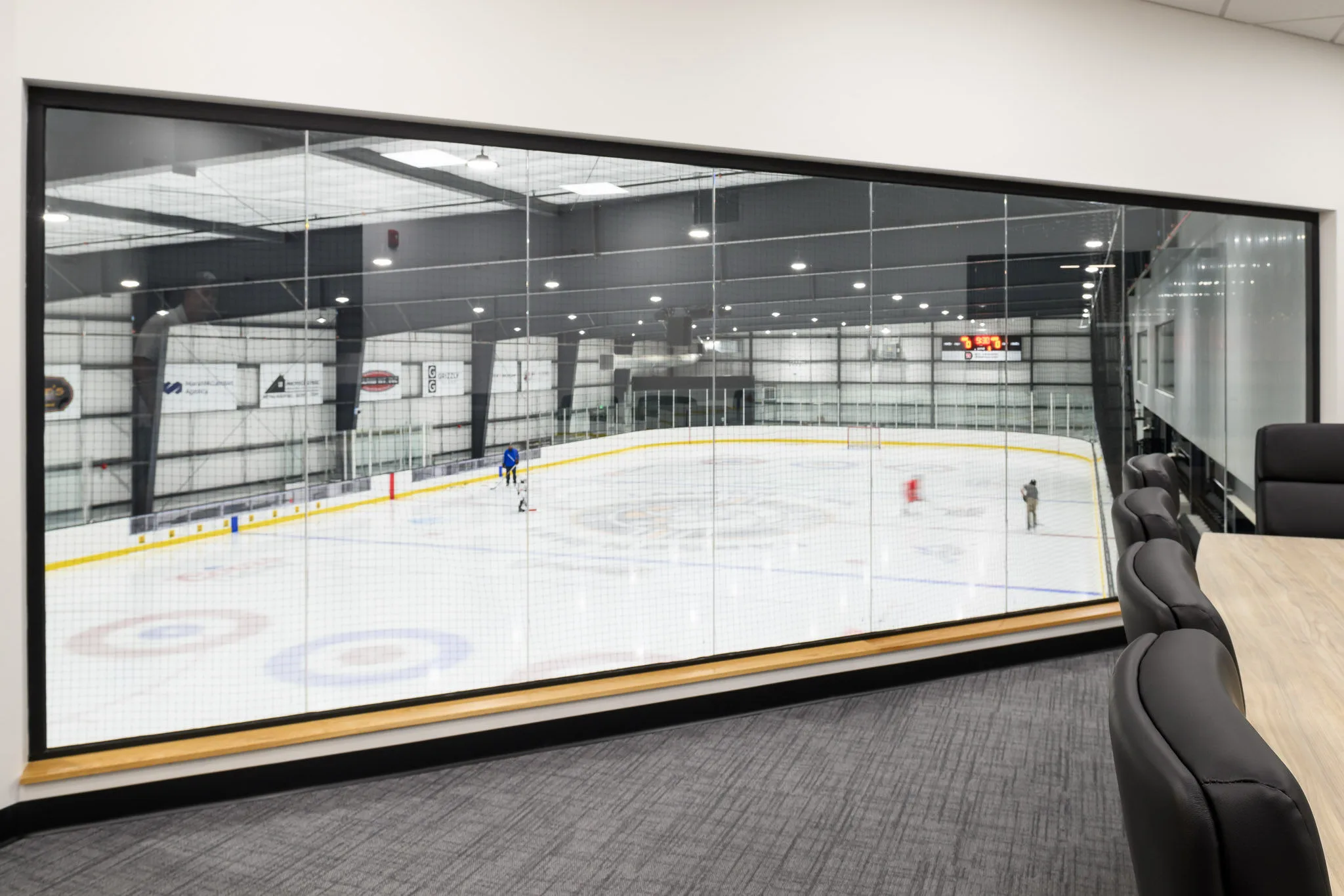 Ice at Signal Peak Energy Arena seen through the full-width window — Signal Peak Energy Ice Arena