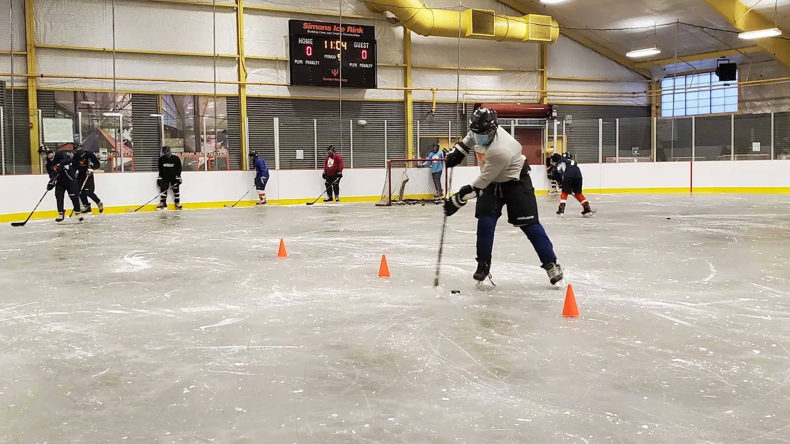 A small group practising hockey among training cones on the indoor ice at Simons Recreation Center. — Simons Ice Rink