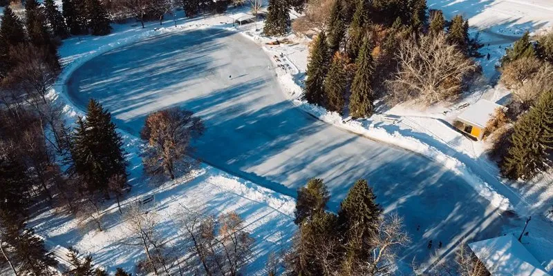 Aerial view of the outdoor ice at Sir Wilfrid Laurier Park in winter, a looping ice surface among snowy trees (City of Edmonton photo) — Sir Wilfrid Laurier Park Outdoor Ice