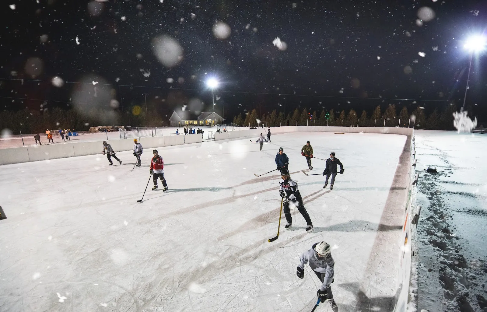 A night hockey game under the lights on the boarded Sister Bay community rink — Sister Bay Ice Skating Rink