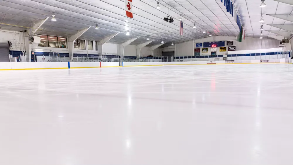 Full ice sheet shot from just above surface level at one end, empty — SkateQuest (Reston)