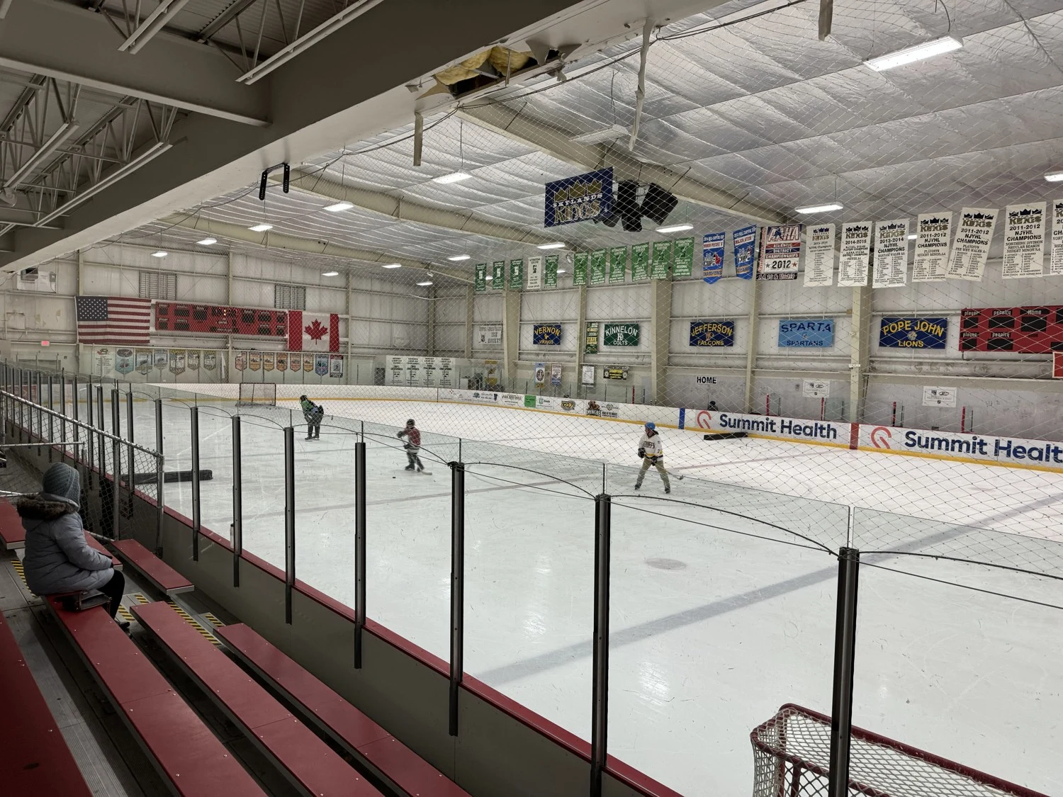Skylands' second rink viewed from the spectator side, with team banners above the boards. — Skylands Ice World