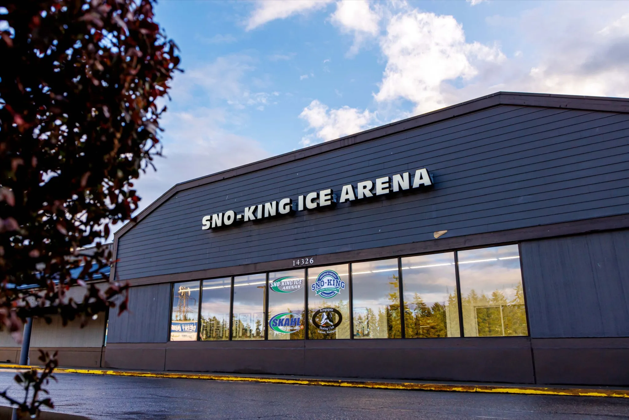 Dark grey clapboard-clad arena with a shallow gambrel roofline — Sno-King Ice Arenas - Kirkland