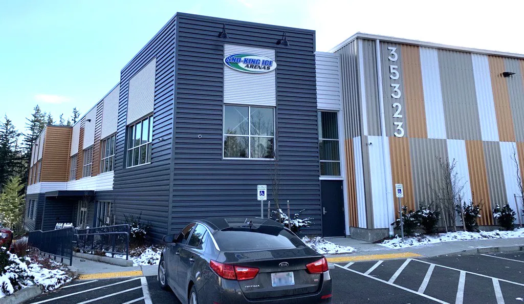 El edificio de Sno-King Ice Arenas en Snoqualmie: el logo en el bloque metálico oscuro de la entrada, junto a la nave rayada de la pista marcada 35323 — Sno-King Ice Arenas - Snoqualmie