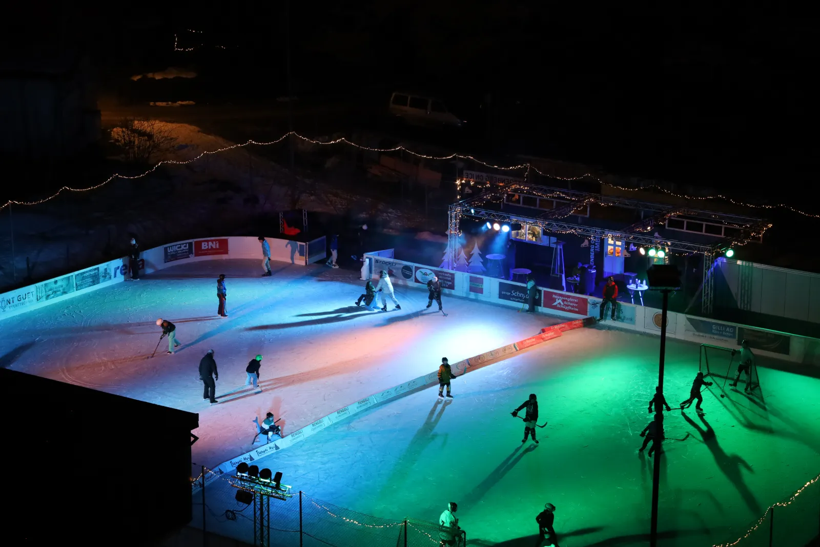 The ice field at Sörenberg on Ice seen from above at night, lit in colours — Sörenberg on Ice