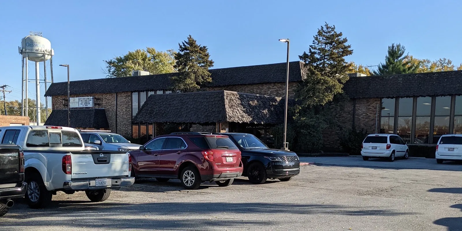 The low brick front of the Southwest Ice Arena on 127th Street in Crestwood, seen across its parking lot with the water tower behind — Southwest Ice Arena