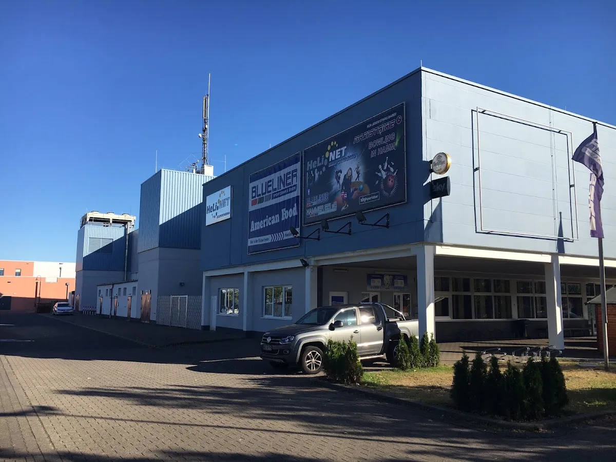 Die blau verkleidete Halle der Spengel Eissportarena in Hamm an einem klaren Tag. – Spengel Eissportarena