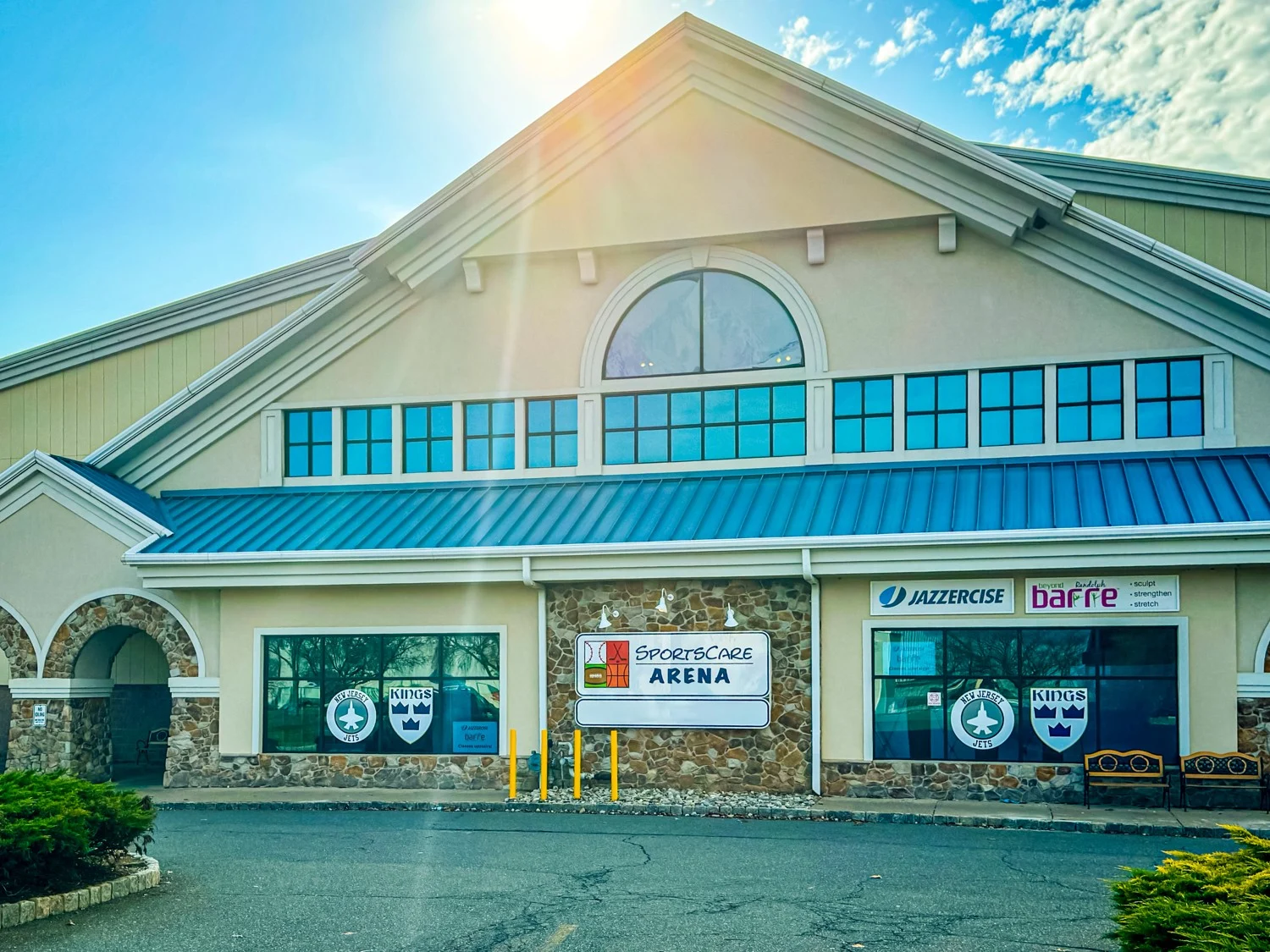 SportsCare Arena's entrance and windows beneath the building's pitched roof. — Sportscare Arena