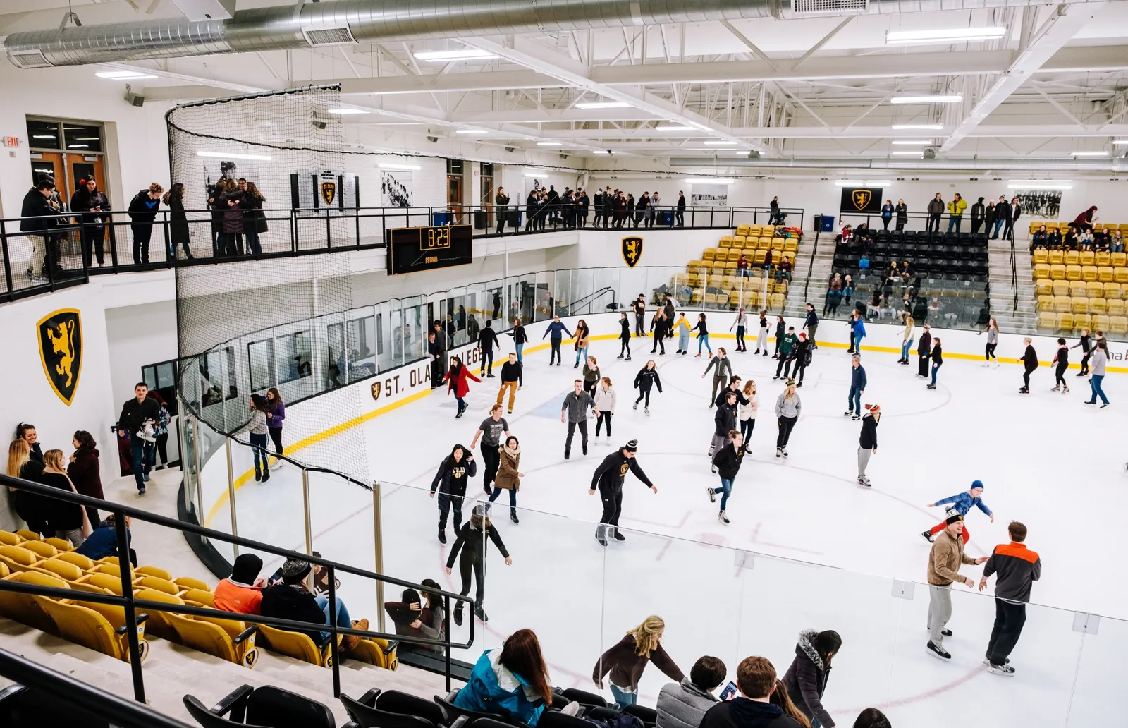 Patinaje público en el St. Olaf Ice Arena, visto desde el nivel superior, con patinadores repartidos por la pista. — St. Olaf Ice Arena