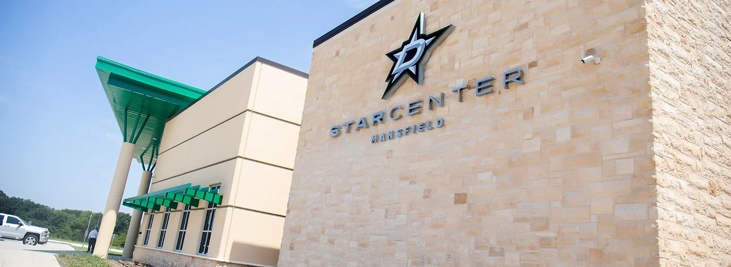 Piedra clara y la marquesina verde, con el logotipo de los Stars en la esquina — Children's Health StarCenter Mansfield