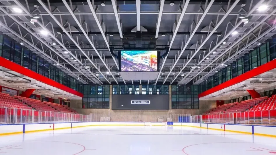 Huaxi LIVE Ice Center, where Starlight Field runs public skating: an empty hockey-size rink with red seating on both sides — Starlight Field International Ice Center