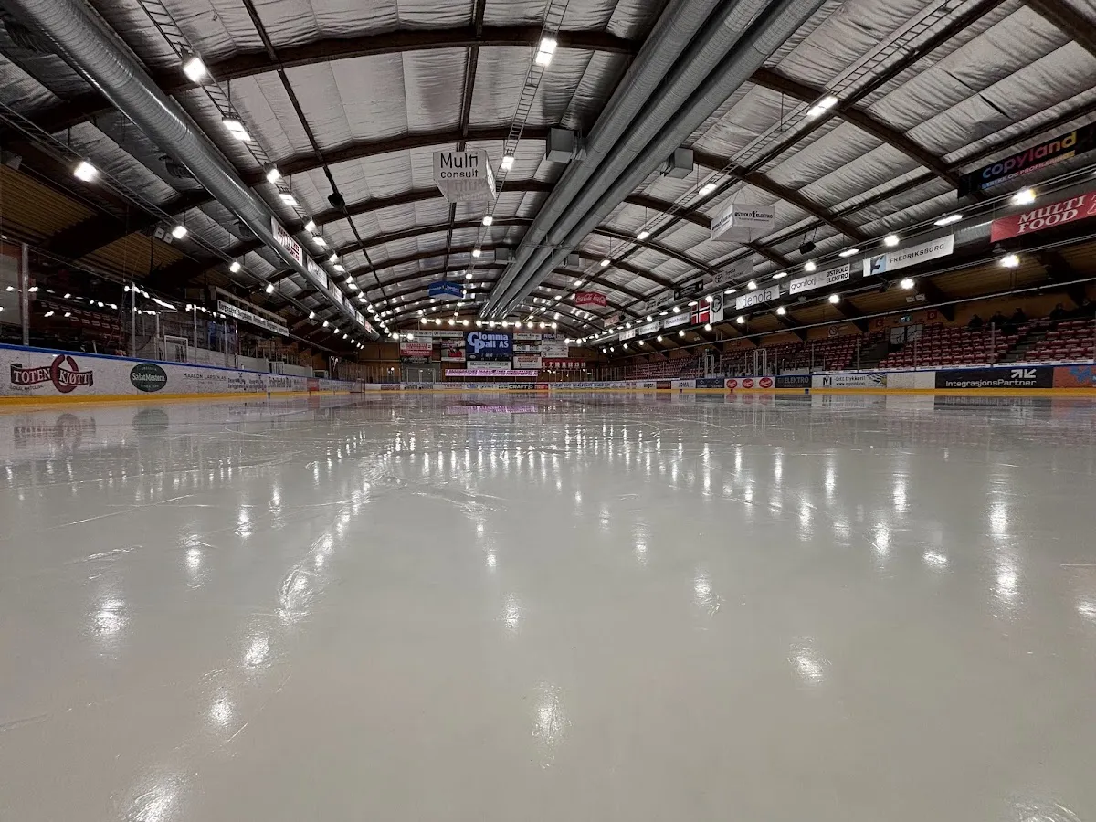 Den tomme isflaten inne i Stjernehallen, sett fra vanten under det buede taket. — Stjernehallen