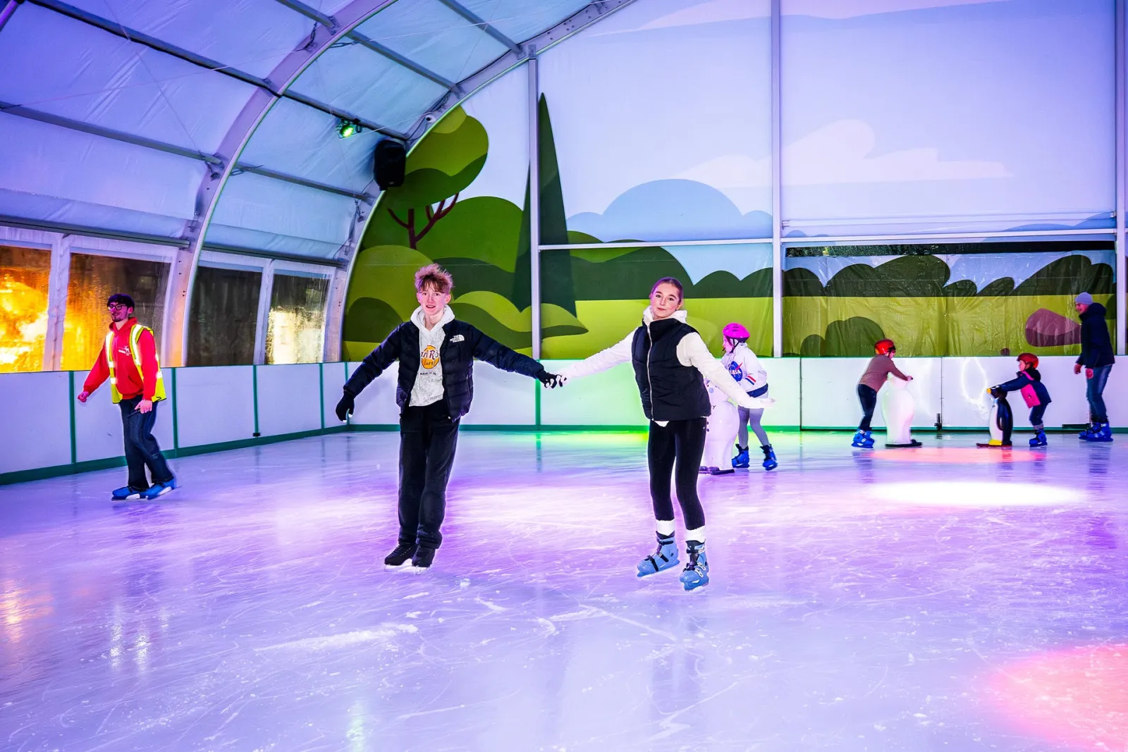 Skaters on the covered rink under coloured lights (the park's photo) — Stockeld Park Ice Rink