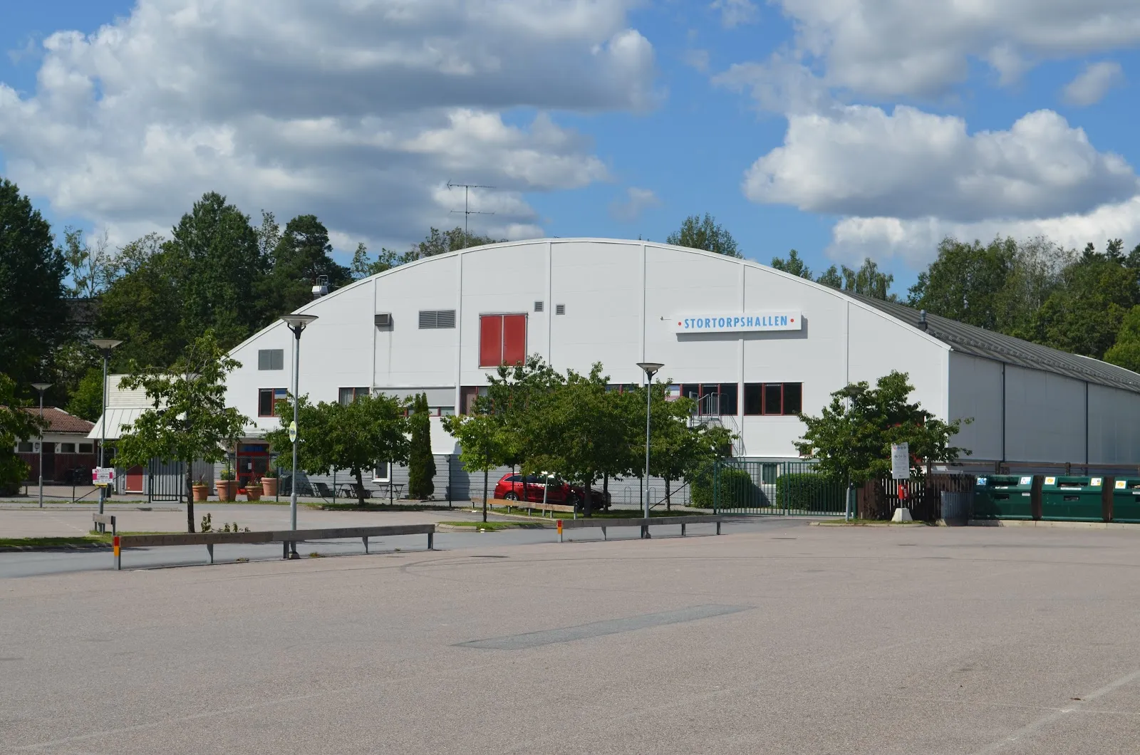 Stortorpshallen in Trångsund, the white arched hall with its sign, seen from the car park — Stortorpshallen