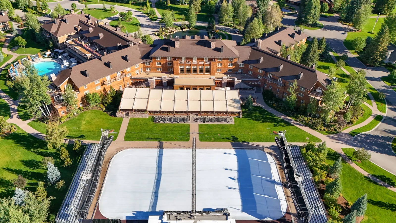 Aerial view of the Sun Valley Lodge and the outdoor ice rink with its two grandstands on the lawn in front of the lodge. — Sun Valley Resort Ice Rink