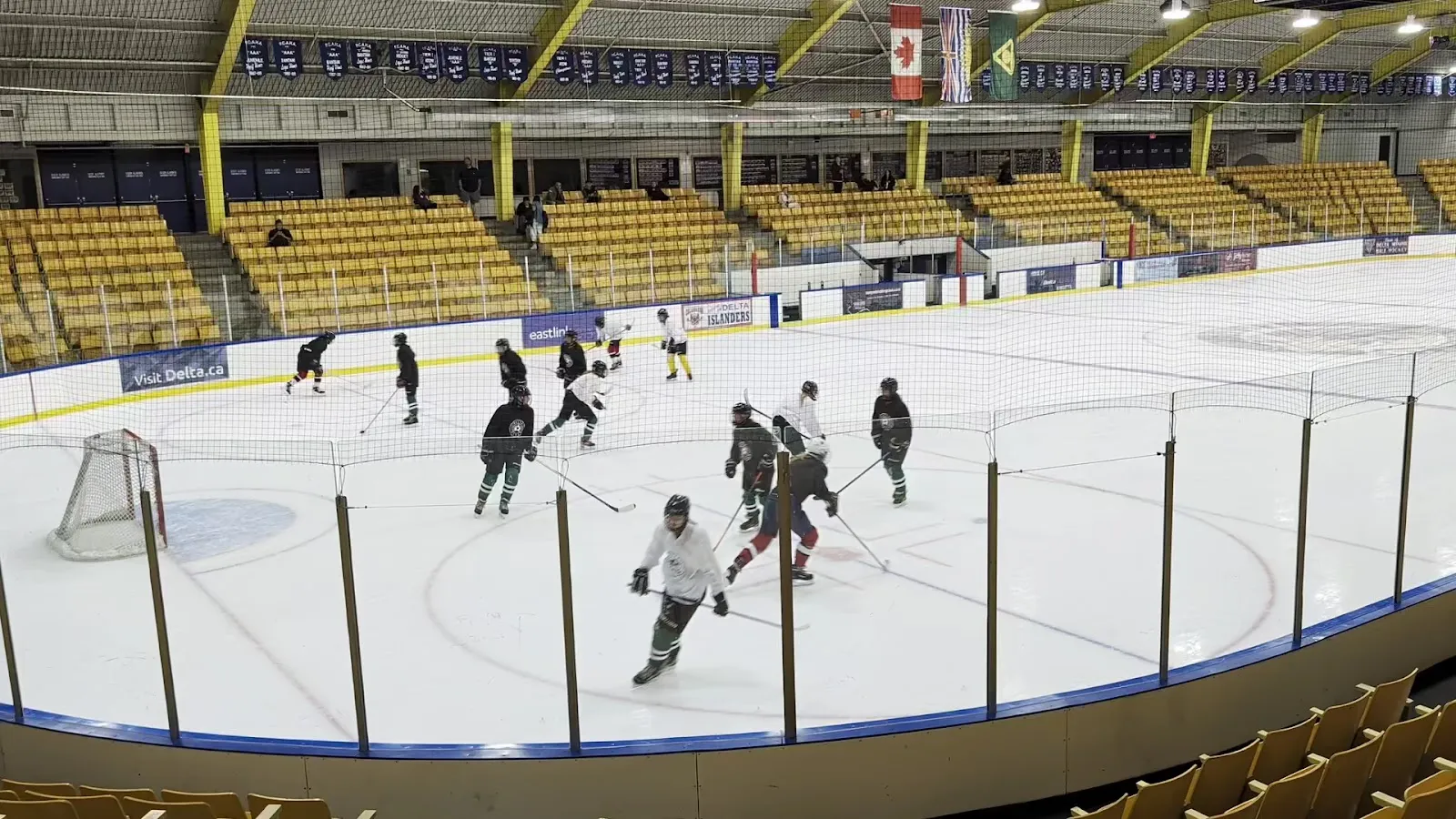 Sungod Recreation Centre arena: a game on the ice with the spectator stands behind — Sungod Recreation Centre