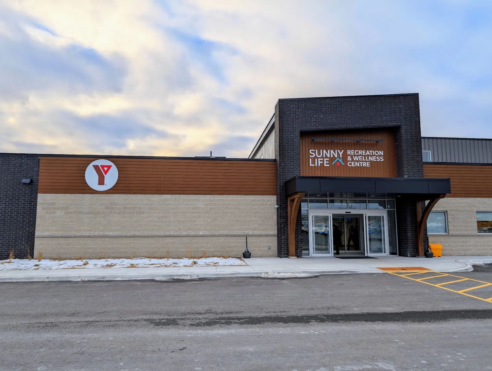 The front of the Sunny Life Recreation & Wellness Centre in Campbellford, with its dark-framed entrance and Sunny Life sign above the glass doors and a YMCA logo on the wall to the left. — Sunny Life Recreation & Wellness Centre