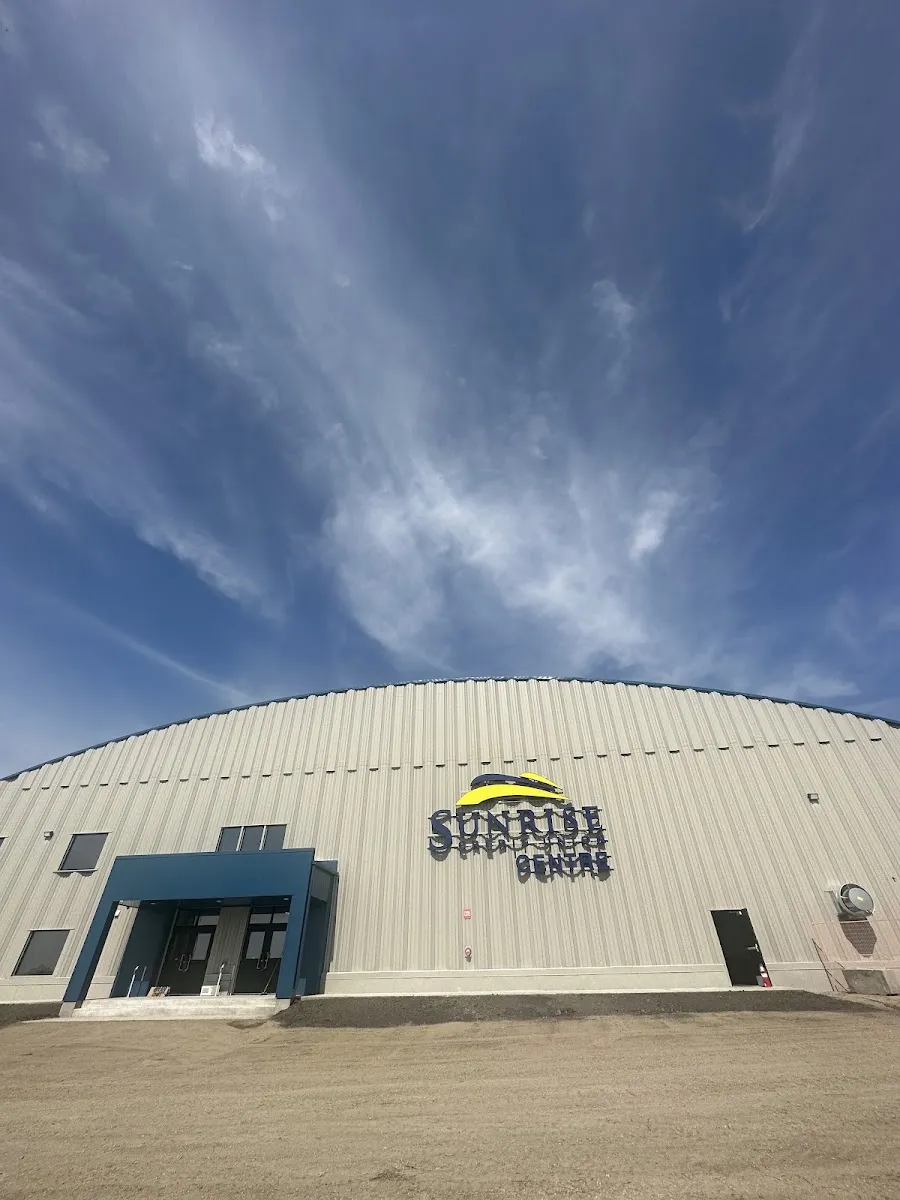 The arena's curved metal wall with the Sunrise Credit Union Centre lettering beside a blue entrance canopy. — Sunrise Credit Union Centre (Minnedosa)