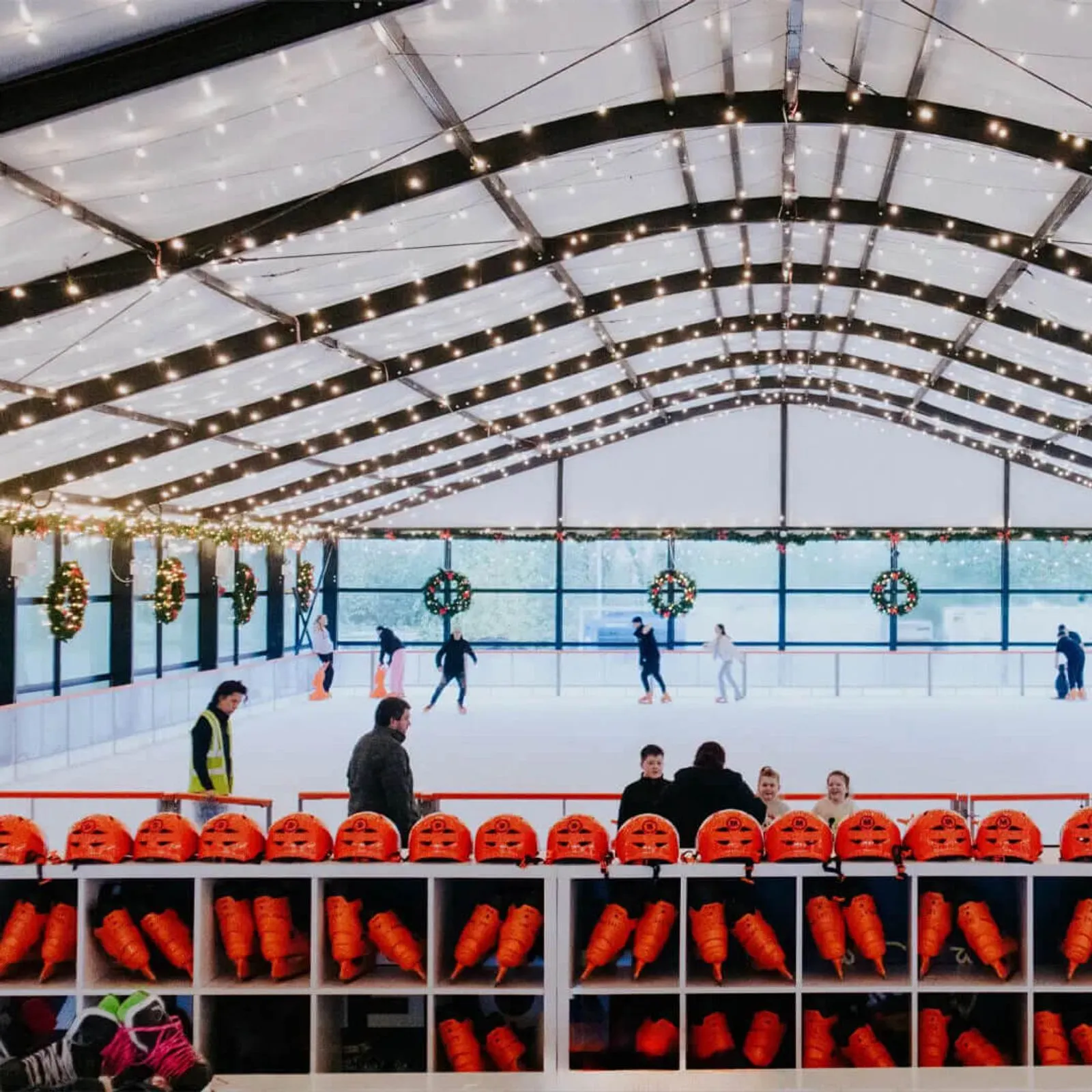 The Swords On Ice rink under its lit marquee, with the orange skate lockers along the near boards — Swords On Ice