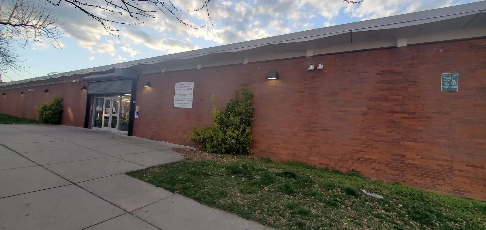 The brick front of the Tarken recreation building with its entrance doors and a lawn. — Tarken Ice Rink