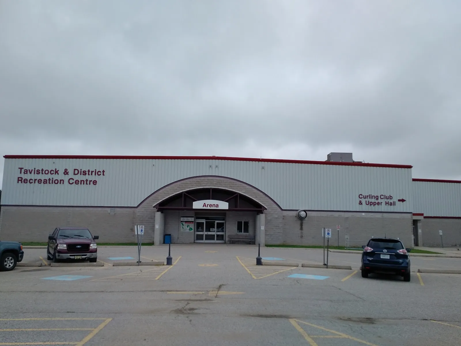 The grey Tavistock & District Recreation Centre with its arched Arena entrance and red roof trim. — Tavistock and District Recreation Centre
