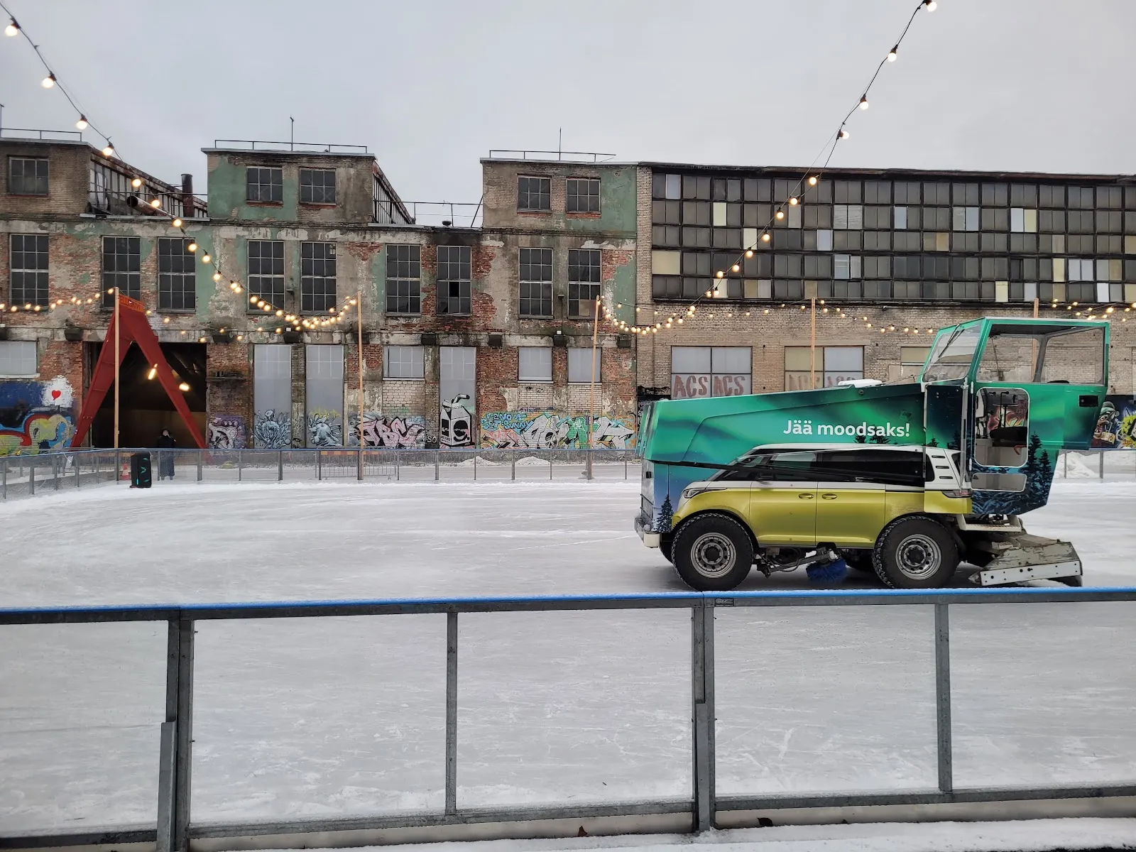 The Telliskivi ice sheet with the ice resurfacer and the old factory buildings beyond — Telliskivi uisuväljak