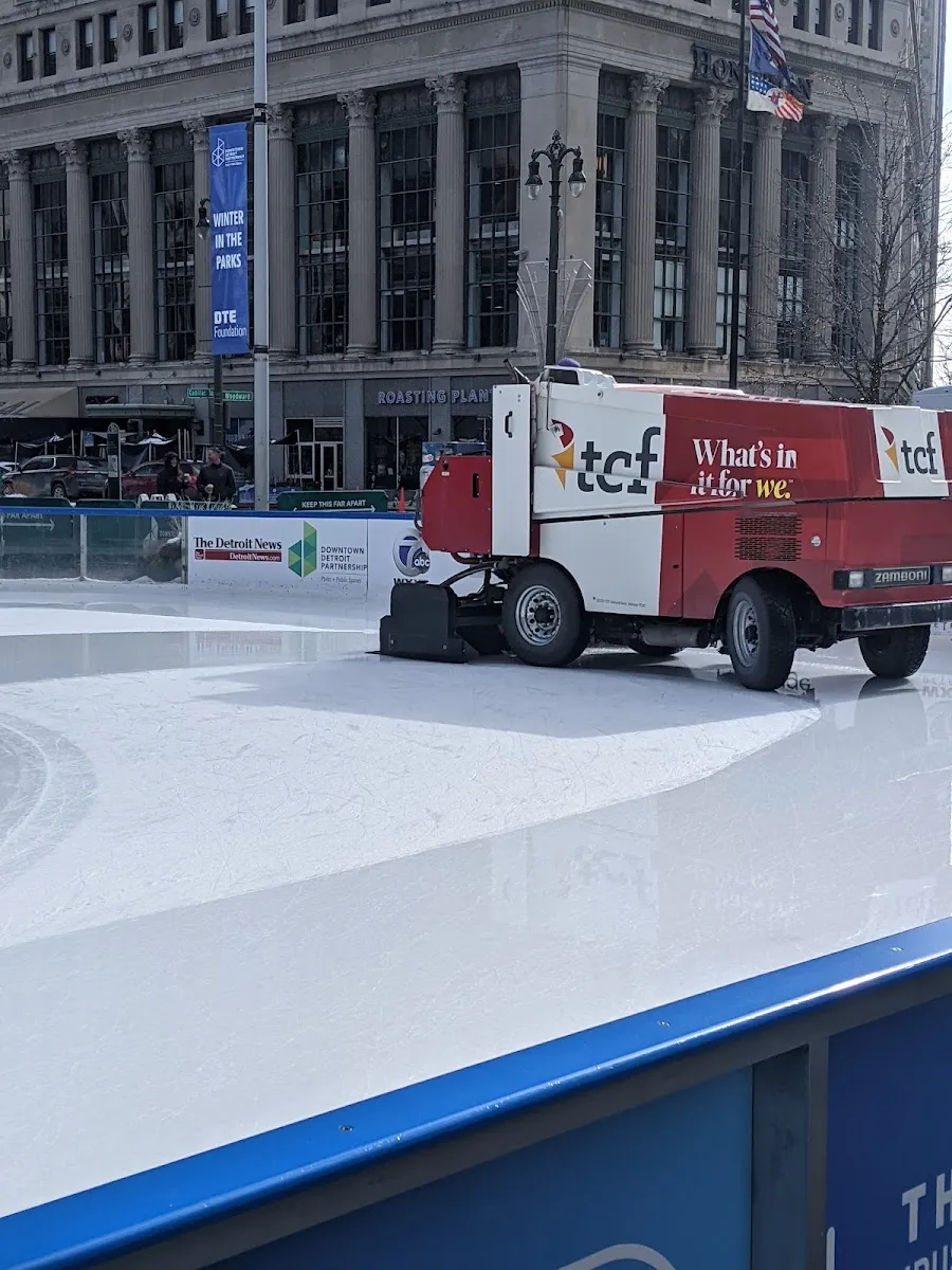 The ice resurfacer on the empty Campus Martius ice with the Woodward Ave buildings beyond — The Rink at Campus Martius Park