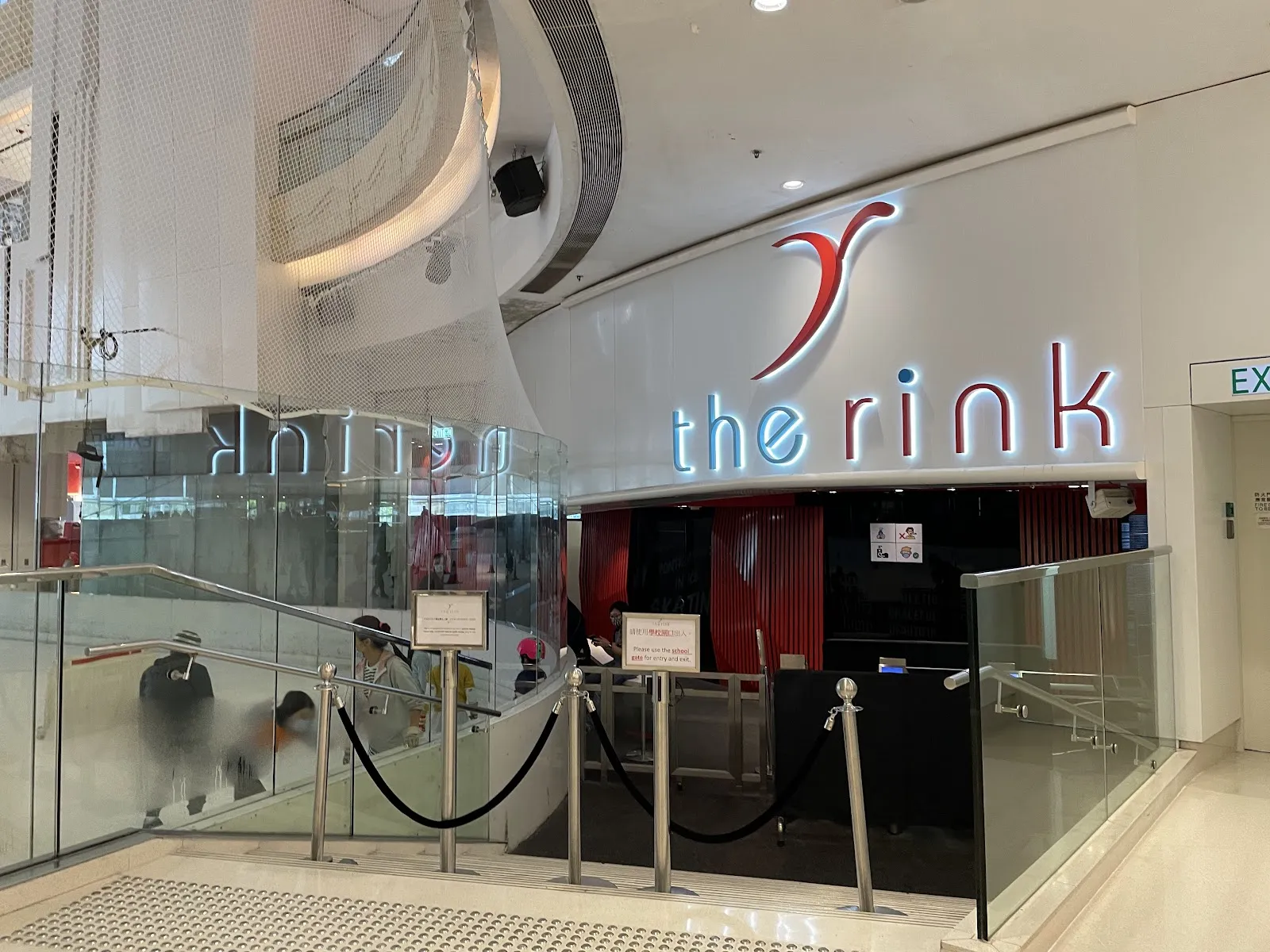 The lit 'the rink' sign over the entrance and stairs down to the ice, inside Elements. — The Rink (Elements)