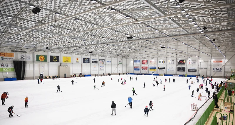 Skaters spread across the ice of Tingvalla isstadion, seen from the stand — Tingvalla isstadion