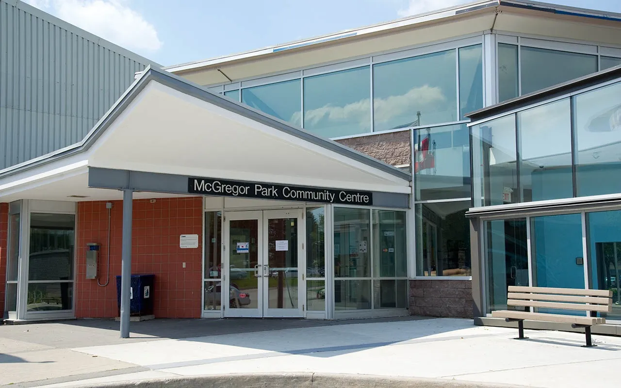 Entrance canopy and glass facade of McGregor Park Community Centre, with benches along the forecourt. — McGregor Park Community Centre