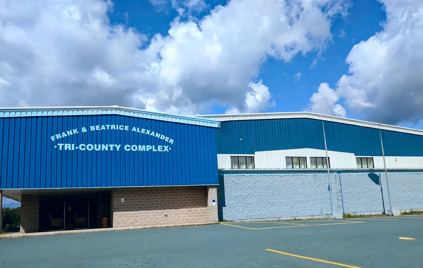 The blue steel front of the Frank and Beatrice Alexander Tri-County Complex with its entrance and car park. — Tri-County Complex