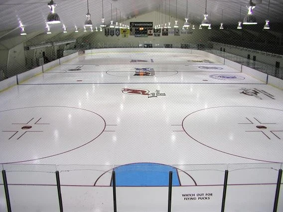 A wide view of Union Sports Arena’s ice beneath its scoreboard and New Jersey Devils markings. — Union Sports Arena