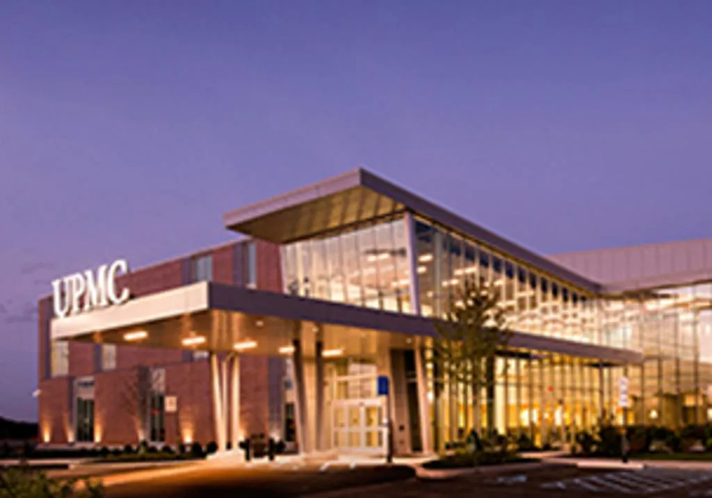 The glass frontage glowing at dusk — UPMC Lemieux Sports Complex
