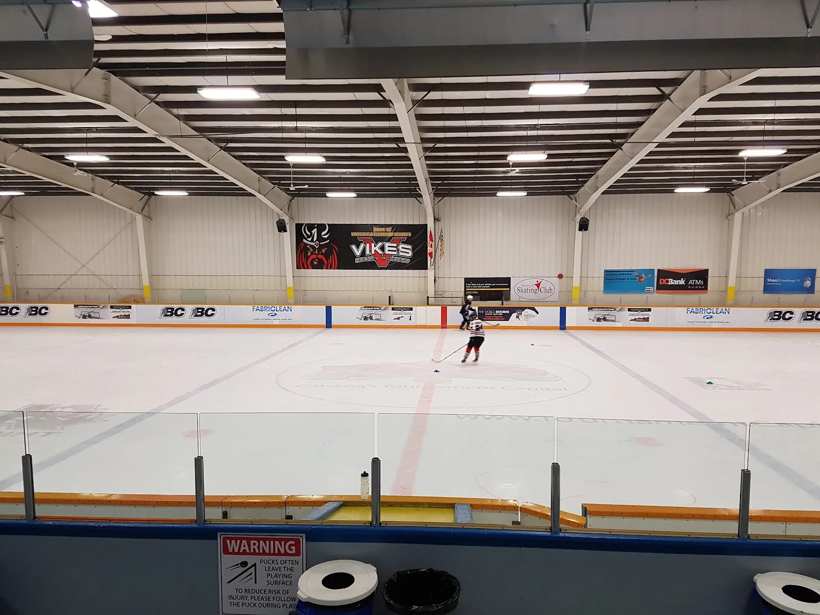 La pista de hielo de Valleyview Arena, con los anuncios de patrocinadores y el techo arqueado de la arena. — Valleyview Arena