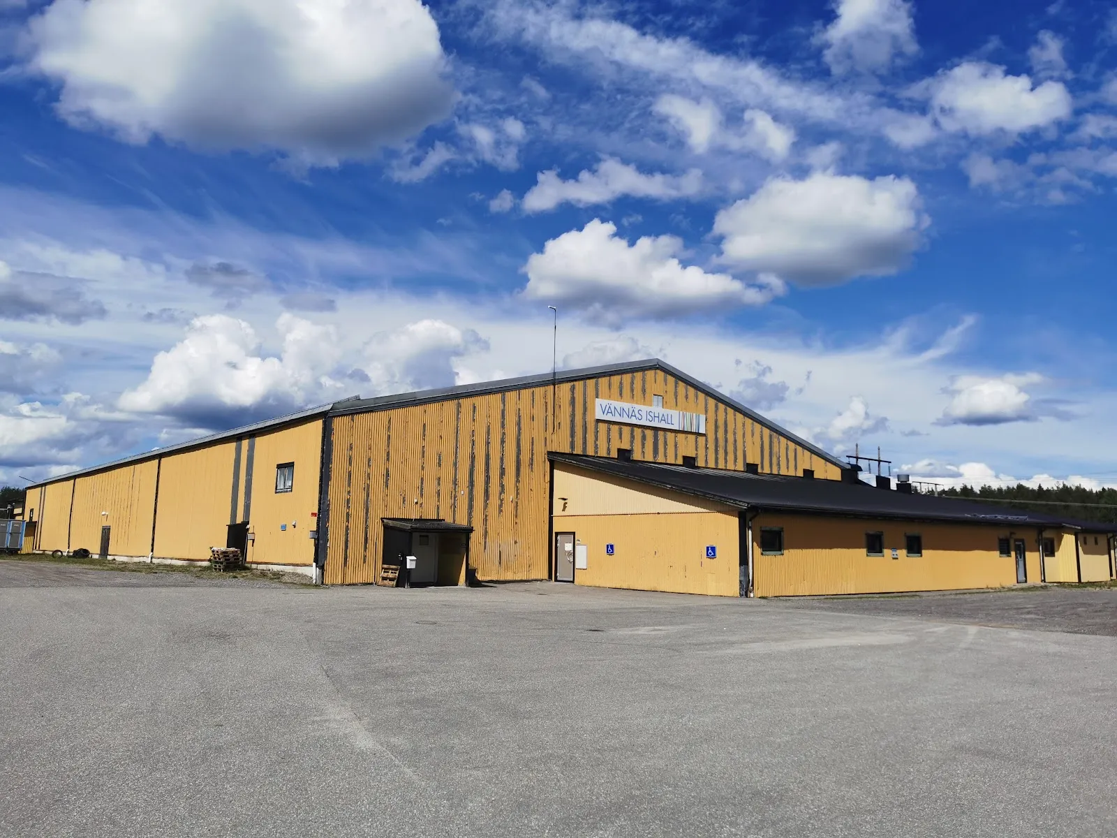 Vännäs ishall, the yellow-clad hall with its name on the gable — Vännäs ishall