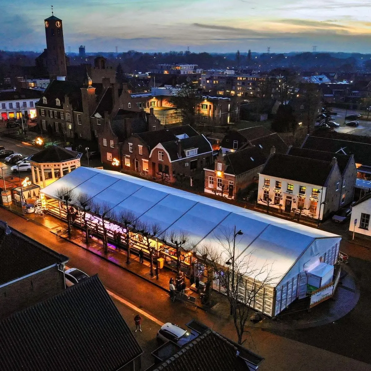Evening view from above of the covered 't Veerse IJsplein tent along the square, with the town buildings around it — 't Veerse IJsplein (Heereplein, Raamsdonksveer)