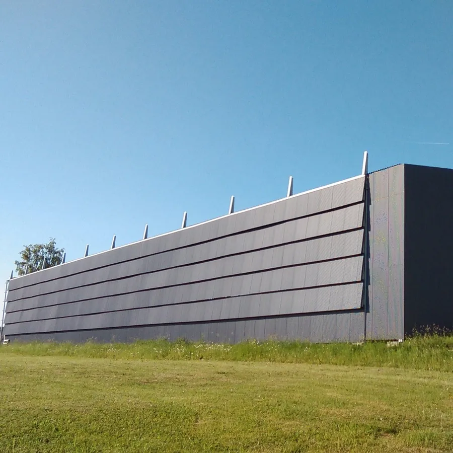 Viljandi Jäähall väljastpoolt: tume kattega halli sein üle muru vaadatuna – Viljandi Jäähall