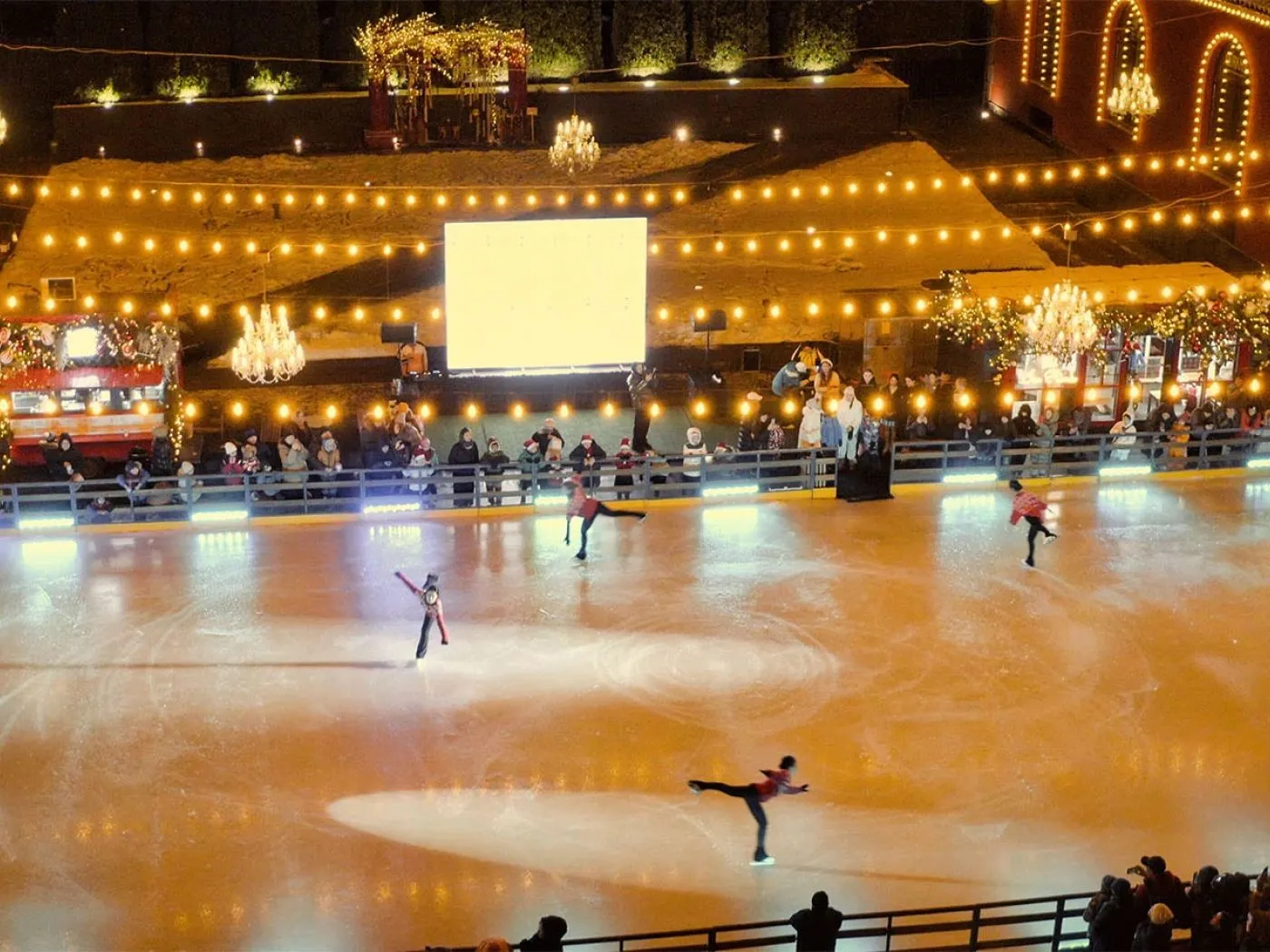Skaters on the ice of the Villa Dei Fiori rink in Almaty, lit by string lights — Villa Dei Fiori Ice Rink