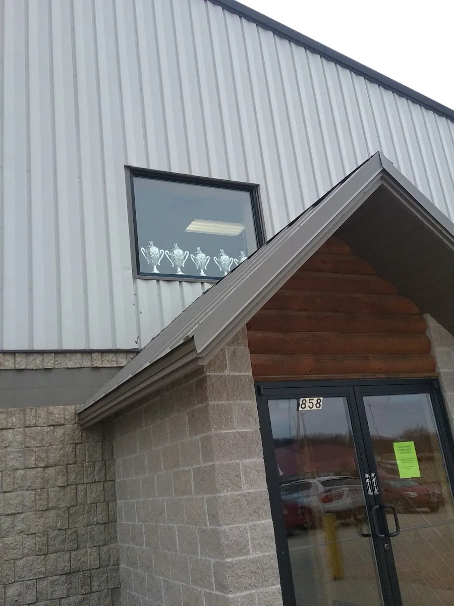 Entrance of Viroqua Community Arena, 858 Nelson Parkway, with the stone and log-clad front and the street number on the door — Viroqua Community Arena