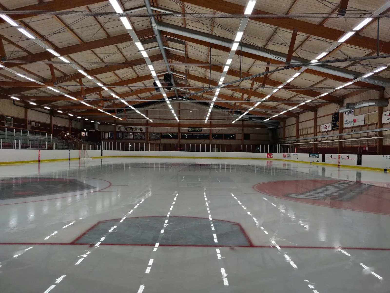 Empty ice of Visättrahallen under its timber-framed roof — Visättrahallen