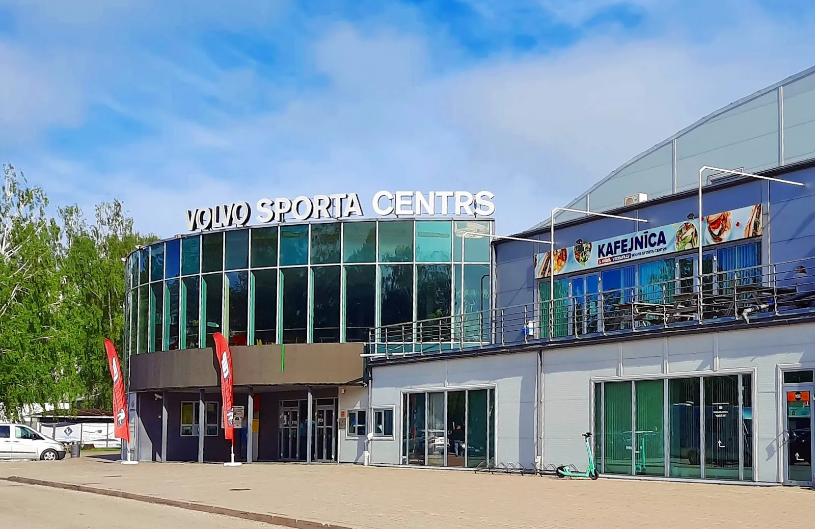 The front of the Volvo sporta centrs building, with the VOLVO SPORTA CENTRS sign over the glazed entrance. — Volvo sporta centrs