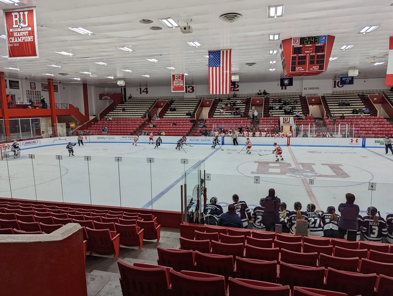 Un partido de hockey femenil en Walter Brown Arena, con el graderío rojo alrededor del hielo. — Walter Brown Arena