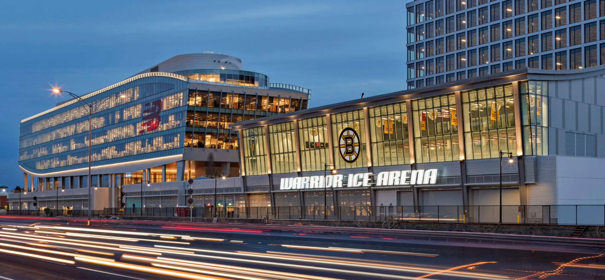 La arena iluminada en la hora azul, vista desde el otro lado de Guest Street — Warrior Ice Arena