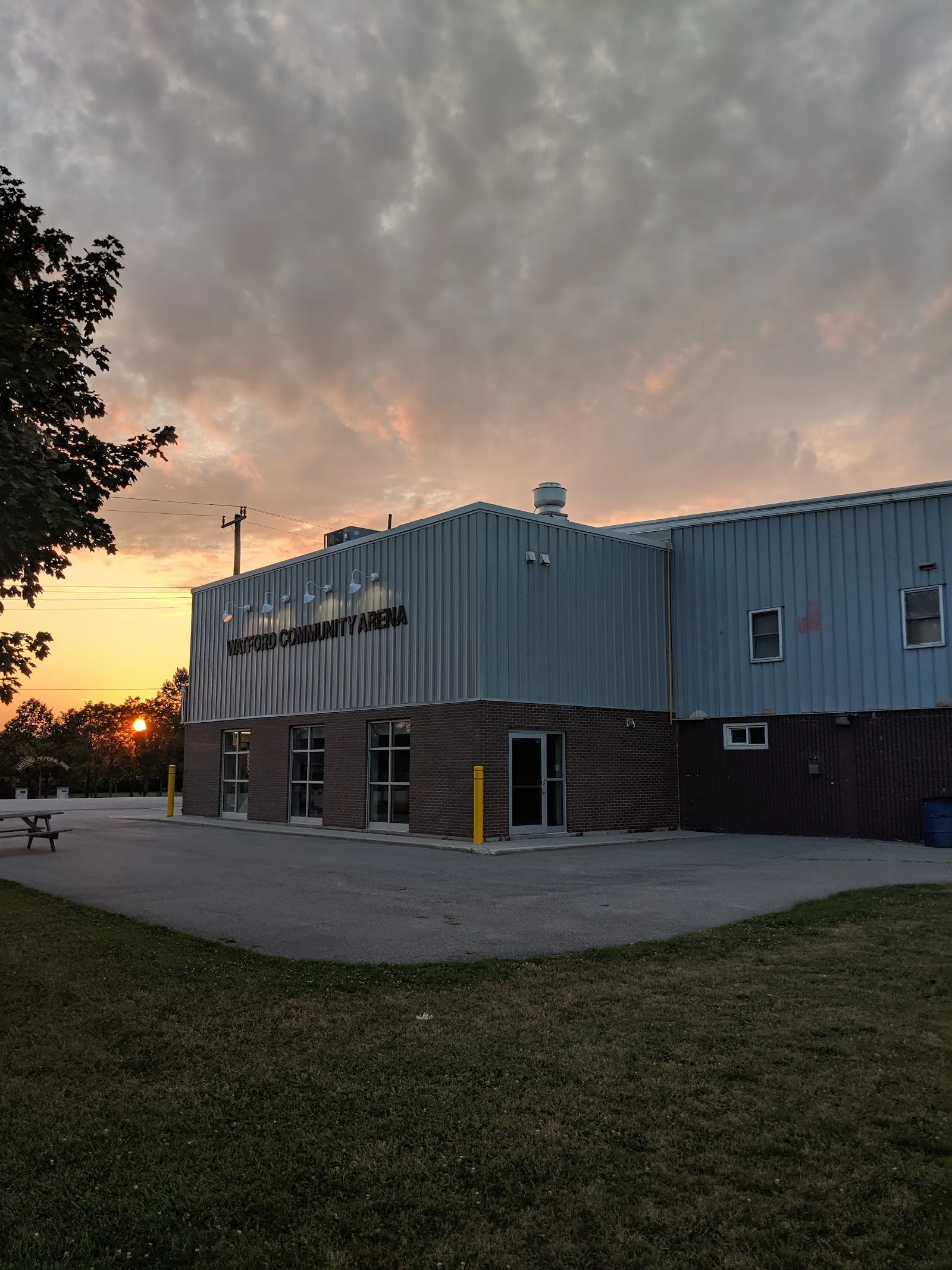 The Watford Community Arena building at sunset, with its name on the wall — Watford Community Arena