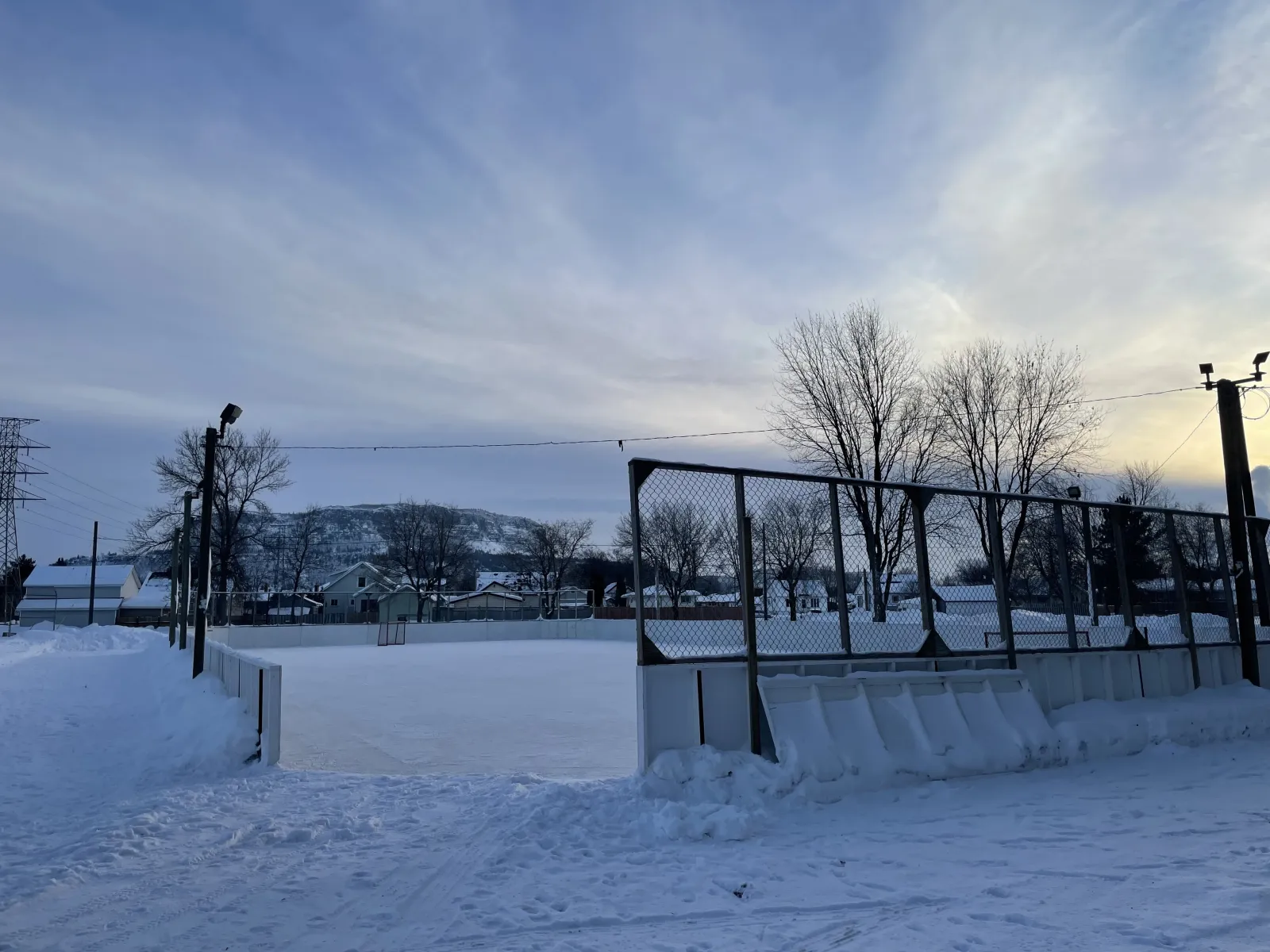 A boarded rink at Wayland Park with the hills beyond — Wayland Park Outdoor Rinks