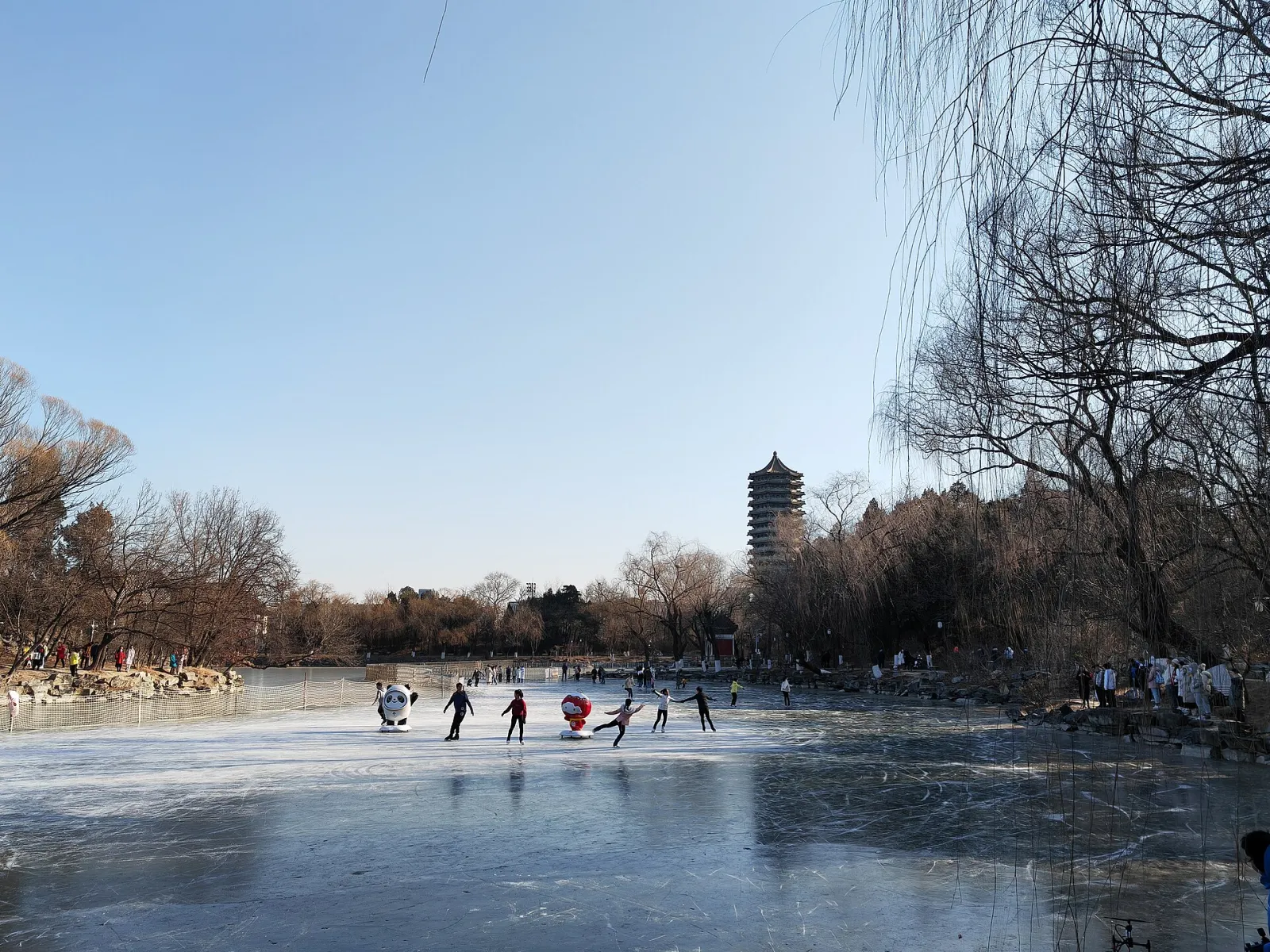 北京大学未名湖冰面上的滑冰者，背景为博雅塔（2022 年 1 月） — Weiming Lake Ice Rink, Peking University (北京大学未名湖冰场)